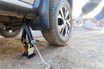 The master changes the wheels of the car. The car is mounted on a jack