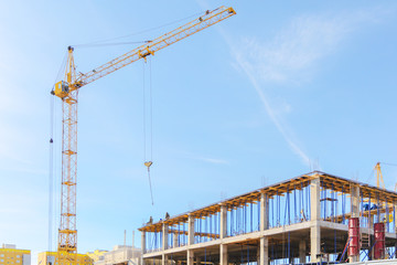 View of a reinforced concrView of the construction site. Tower crane at a construction site. Monolithic frame of the building