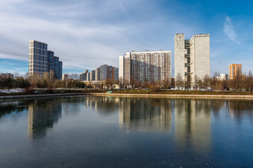 Obraz na płótnie Canvas Landscape with lake in the Friendship park in Moscow. Russia. Buildings are reflected in the water