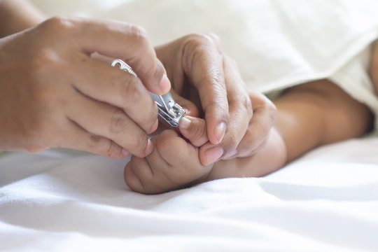 mother cutting babies nails.care concept.