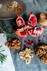 Pomegranate fruit, walnuts, cashew nuts on the table - healthy food products