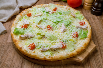 Pizza Caesar with chicken and tomatoes on the board