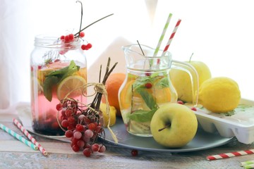 
Summer refreshing cocktail, detox water from organic fruits and berries, mint leaves in glass jugs on a wooden table, healthy nutrition