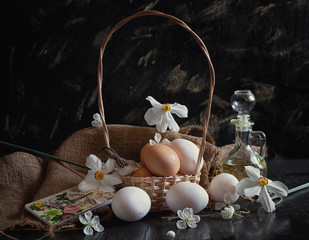 many easter eggs in a basket with flowers on a black background