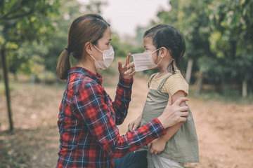 Young mother is wearing a sterile medical mask for her baby. To prevent from getting infected with the Covid-19 virus, the outbreak and spread of the disease.