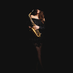 Saxophone player. Jazz musician saxophonist woman playing sax player isolated on black