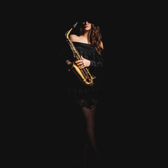 Obraz premium Saxophone player. Jazz musician saxophonist woman playing sax player isolated on black
