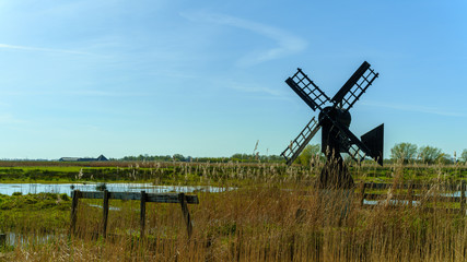 Classic small windmill in typical Dutch landscape