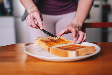 Obraz na płótnie Canvas two hands spreading butter on toast