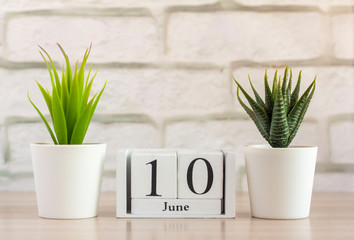 June 10 on a wooden calendar. Summer day, empty space for text.Calendar for June on a light background.