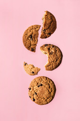 Whole oatmeal cookies and pieces float in the air on a pink background. Concept of the morning Breakfast.