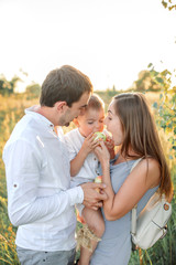 Obraz premium Happy family - father, mother, baby son have fun together. Travel lifestyle, parents with kids on summer vacation