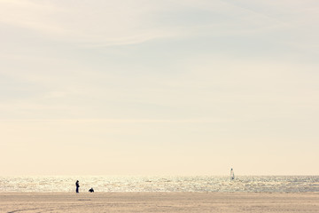 Lonely person on the beach over sea. Spring walks on a sunny day on the sandy Baltic beach in Estonia