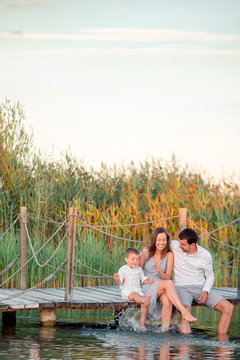Happy family - father, mother, baby son have fun together. Travel lifestyle, parents with kids on summer vacation