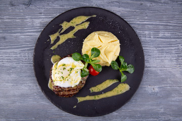 A piece of steak with egg paschot, served with puree potatoes and cherry tomatoes with greens