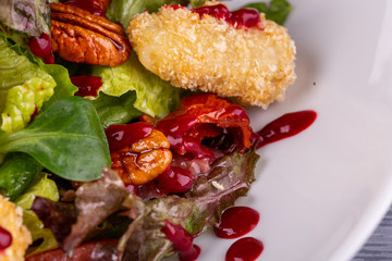 Salad with chicken fillet in bread crumbs, served with pecan nuts and fresh salad