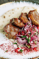 Restaurant dish on a wooden background. Azerbaijani shish kebab and grilled ribs.