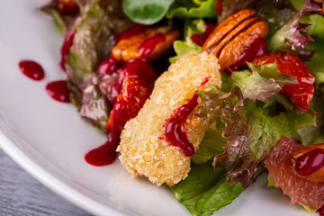 Salad with chicken fillet in bread crumbs, served with pecan nuts and fresh salad