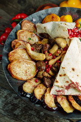  Restaurant dish on a wooden background. Azerbaijani saj with meat and vegetables.