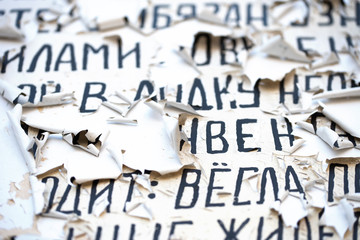 Cyrillic black letters on white cracked paint old surface