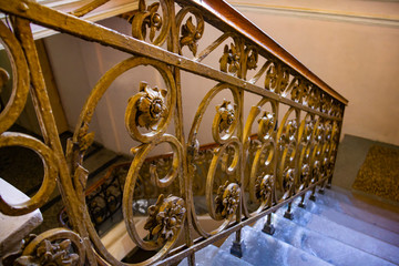 An old stairs with gold metal banister in empty building
