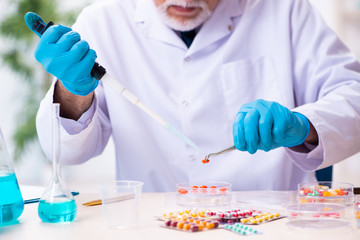 Old male chemist working in the lab