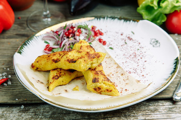  Restaurant dish on a wooden background with vegetables. Vegetarian Lula kebab made of mashed potatoes with onions on pita bread.
