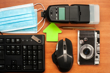 Flat assembly composition with masks, keyboard, flash, mouse, pen, usb pen, block notes and flash on wooden background