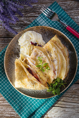 Crepes with ricotta cheese and blackcurrant jam.