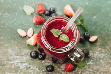 Berry smoothie on rustic background, top view