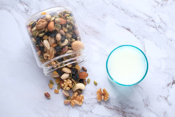  close up of mixed nut in a bowl and milk on table 