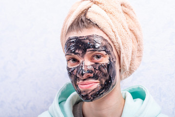Portrait of a young attractive woman with a moisturizing and cleansing black face mask