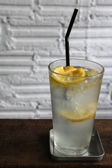 Iced lemon soda glass on wooden table.
