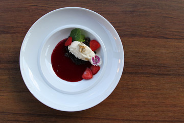 Japanese desserts decorated with fruit, flowers and whipped cream with gold leaf on top.