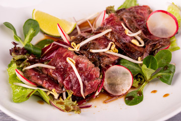 Warm beef salad with terriaki sauce, served with radish, lime and fresh salad