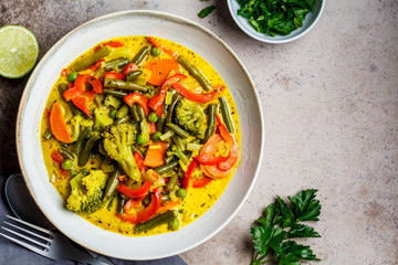 Broccoli and green beans curry bowl with coconut milk, top view.