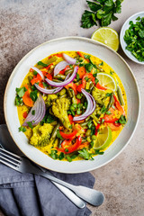 Vegetarian curry with broccoli, pepper, green beans and coconut milk in a bowl, top view.