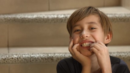 Naughty boy, shows his tooth about to fall out, showing loose tooth