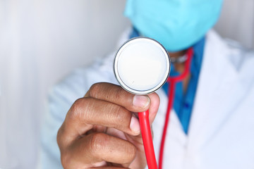 Doctor using stethoscope in hospital, close up