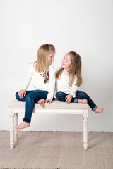 niñas felices sonrientes sentadas estudio fondo blanco