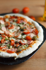 homemade pizza with sausage and cherry tomatoes close-up on a wooden table. culinary concept