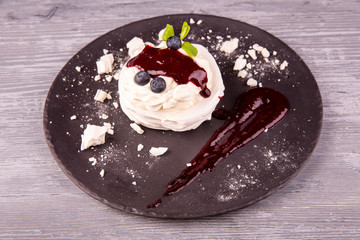 Dessert Pavlova with gentle cream, whipped cream, served with berries and jam