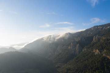 Drone shot of cloud coming from behind the moutain in Orient/Mallorca