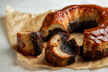 chocolate flan, Mexican chocoflan, chocolate biscuit cake and caramel custard pudding with a caramel sauce on top, on te dark wooden table
