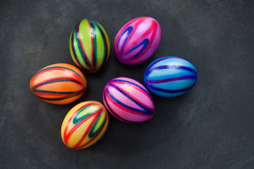 farbig bemalte Ostereier liegen auf einer schwarzen Schale