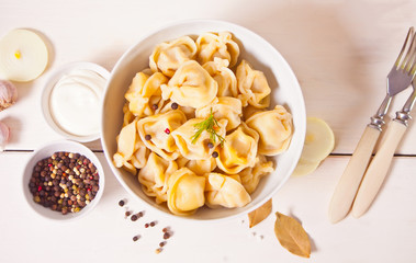 Homemade russian pelmeni meat dumplings italian ravioli in the white bowl.