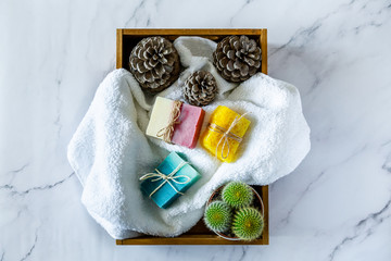 Top view of spa box with organic handmade soap bars with white marble background.