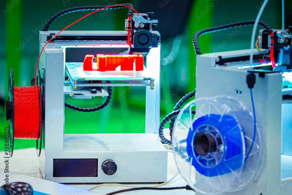 Poster 3d printers close up. print objects from blue and red materials. method of layer-by-layer model cons