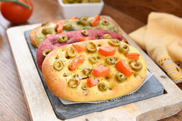 variety of different focaccia, with pumpkin, carrot and beet, on a rustic table
