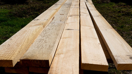 a pile of fresh pine planks on the ground